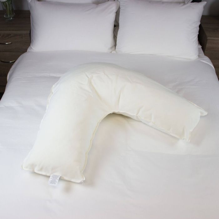 V shaped pillow sitting on bed, with waterproof and flame retardant protection,